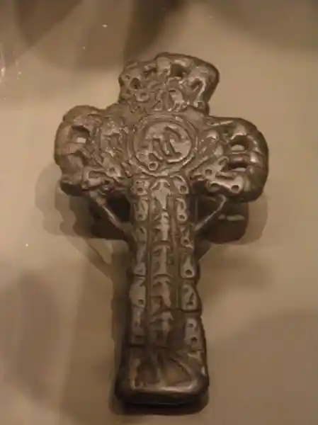 Bronze crucifix with symbols engraved on it.